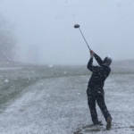 teeing off playing golf in the snow