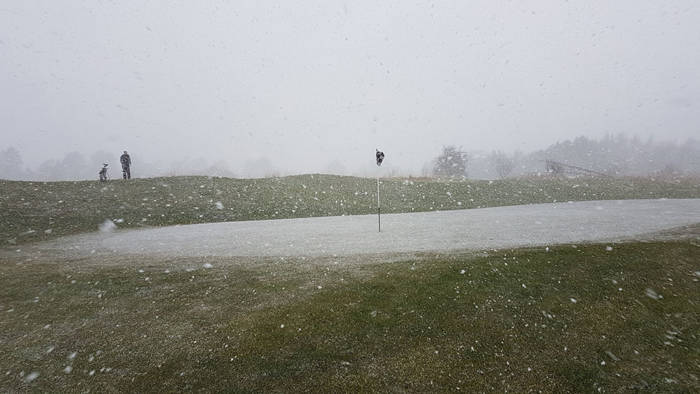 Golf green covered in snow whilst playing golf