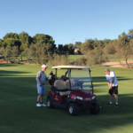 golfers in a golf buggy on the fairway