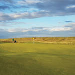 team of golfers chipping to a green