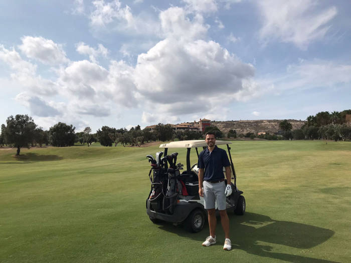 golfer stood in front of a buggy on the fairway